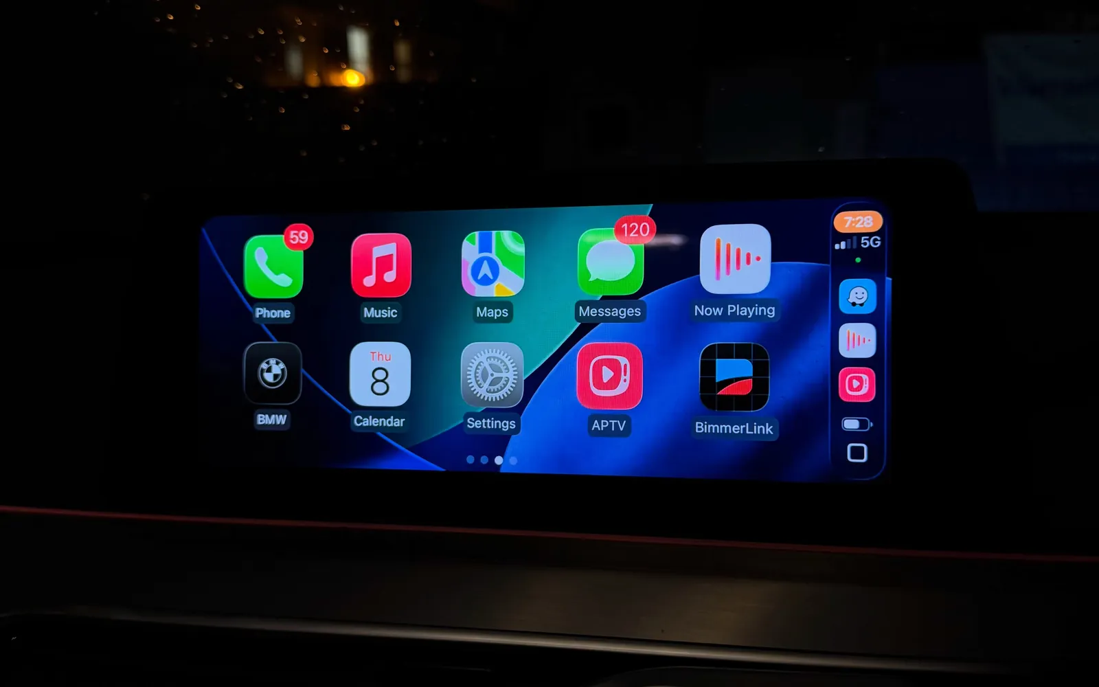 Fullscreen Apple CarPlay home screen on the iDrive display of a BMW G30 530d